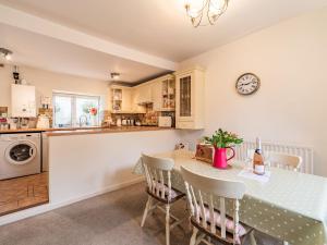 a kitchen and dining room with a table and a clock at Peaseblossom House in Alnwick