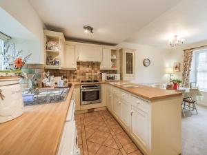 a kitchen with white cabinets and a counter top at Peaseblossom House in Alnwick +10 photos