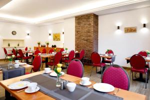 a dining room with tables and red chairs at Vinotel Dirmstein in Dirmstein +8 photos