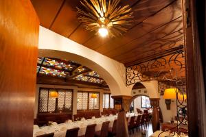 a dining room with tables and chairs and a chandelier at Vinotel Dirmstein in Dirmstein