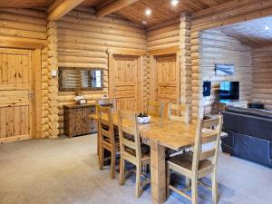 a dining room with a wooden table and chairs at Tweed Log Cabin-Uk3479 in West Thirston