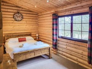 a bedroom with a bed in a log cabin at Tweed Log Cabin-Uk3479 in West Thirston +5 photos