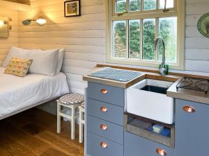 a kitchen with a sink and a bed in a room at The Shepherds Hut - Uk50986 in Sheriff Hutton