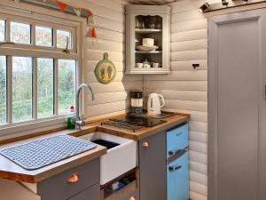a small kitchen with a sink and a stove at The Shepherds Hut - Uk50986 in Sheriff Hutton