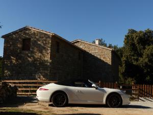a white car parked in front of a stone building at Maison d'Hôtes Zella in Bains de Guitera