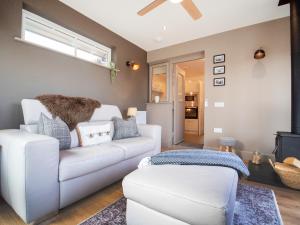 a living room with a white couch and a chair at Dalmore-Ukc5067 in Aviemore