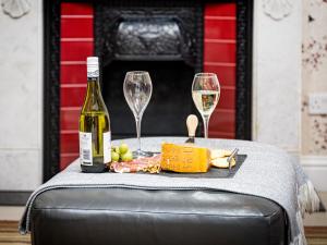 a bottle of wine and two glasses on a table at The Courtyard Apartment - Ukc6965 in Panbride