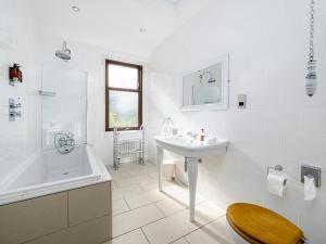 a white bathroom with a sink and a tub and a toilet at The Courtyard Apartment - Ukc6965 in Panbride +6 photos