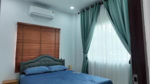 a bedroom with a blue bed and a window at บ้านพักขอนแก่น888 in Ban Non Muang +5 photos
