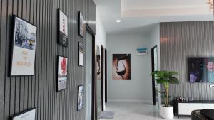 a hallway with framed pictures on a wall at บ้านพักขอนแก่น888 in Ban Non Muang