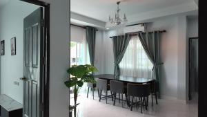 a dining room with a black table and chairs at บ้านพักขอนแก่น888 in Ban Non Muang