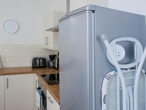 a refrigerator in a kitchen with a chair in it at Shirehampton Apartment in Shirehampton