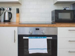 a kitchen with a microwave and a stove with a towel at Shirehampton Apartment in Shirehampton
