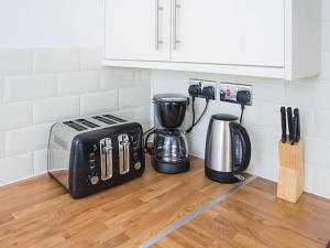 a kitchen counter with appliances on a wooden floor at Shirehampton Apartment in Shirehampton