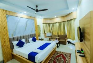 a bedroom with a large bed and a couch at Hotel Sapphire International in Puri