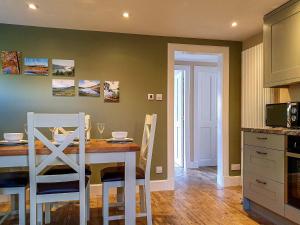 a kitchen with a dining room table with two chairs at Oakbank Cottage - Uk7574 in Pitlochry