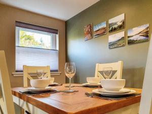 a dining room table with glasses and plates on it at Oakbank Cottage - Uk7574 in Pitlochry