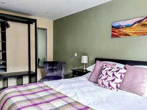 a bedroom with a bed and a chair at Oakbank Cottage - Uk7574 in Pitlochry +6 photos