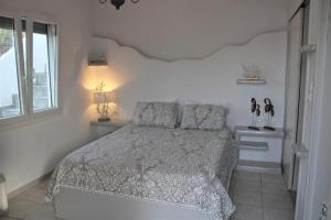 a white bedroom with a bed and a window at SunΚissed Suite - Pollonia Milos in Pollonia