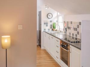 a kitchen with white cabinets and a clock on the wall at Number Three - Ukc4965 in Tawstock