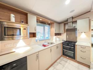 a kitchen with white cabinets and black appliances at Regent 2 in St. Andrews