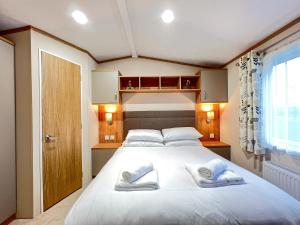a bedroom with a large white bed with two towels at Regent 2 in St. Andrews