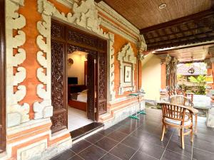 a room with a table and a chair and a bedroom at Puri Anyar Ubud by Puri Signatures in Ubud