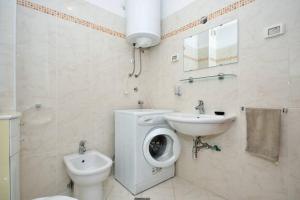 a bathroom with a toilet sink and a washing machine at APP Petre in Umag