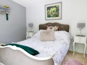 a bedroom with a white bed and two night stands at The Stable At Hilltop Farm in Mottisfont