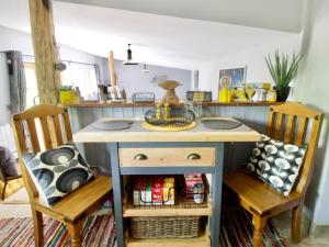a desk in a room with two chairs and a table at The Stable At Hilltop Farm in Mottisfont