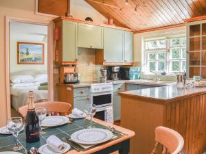 a kitchen with a table with wine glasses on it at The Stables in Winfrith Newburgh