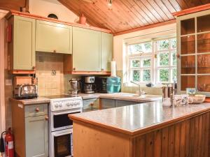 a kitchen with white appliances and a wooden ceiling at The Stables in Winfrith Newburgh