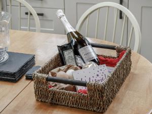 a basket with a bottle of wine on a table at Jasmine Cottage - Uk35245 in Llanfyrnach +23 photos