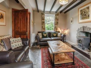 a living room with leather furniture and a fireplace at Jasmine Cottage - Uk35245 in Llanfyrnach