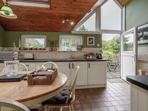 a kitchen with a table and some chairs in it at Jasmine Cottage - Uk35245 in Llanfyrnach