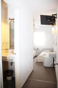 a bathroom with a sink and a bed at Hotel Americana in Punta del Este