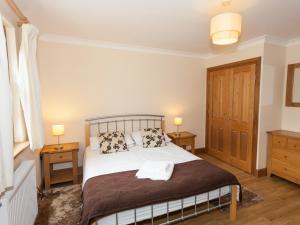a bedroom with a bed with two night stands and two lamps at Honeysuckle Cottage - Ukc6255 in Linlithgow