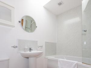 a white bathroom with a sink and a shower at Honeysuckle Cottage - Ukc6255 in Linlithgow +3 photos