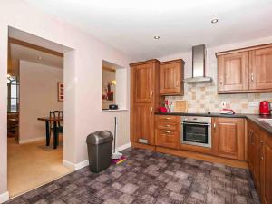 a kitchen with wooden cabinets and a trash can at Larrach Beag-Ukc5059 in Aviemore