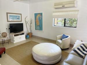 a living room with a couch and a tv at Casa Bella in Bongaree