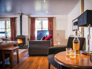 a living room with a bottle of wine on a table at Golden Eagle-Ukc5057 in Aviemore