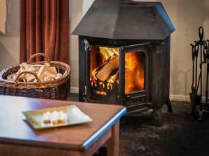 a fireplace with a plate of food on a table at Golden Eagle-Ukc5057 in Aviemore