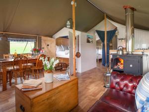 a living room with a fireplace in a tent at 1 Lower Keats Glamping - Ukc4746 in Chardstock
