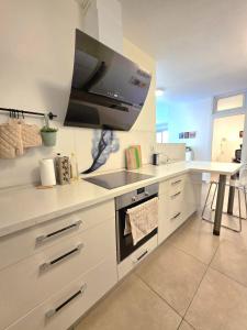 a kitchen with a sink and a tv on the wall at Your home in Pardes Hanna in Pardes H̱anna