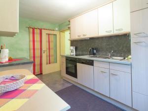 eine Küche mit weißen Schränken und einem Waschbecken in der Unterkunft Apartment close to hiking and cycling trails in Lambertsberg