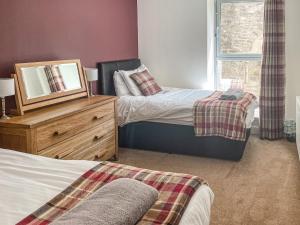 a bedroom with two beds and a mirror on a dresser at Raven Wing 17 - Ukc4882 in Fort Augustus