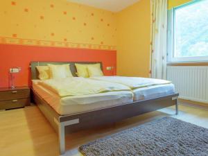 ein Schlafzimmer mit einem großen Bett mit gelben Wänden und einem Fenster in der Unterkunft Apartment close to hiking and cycling trails in Lambertsberg