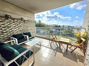 a balcony with a couch and chairs and a table at Your home in Pardes Hanna in Pardes H̱anna