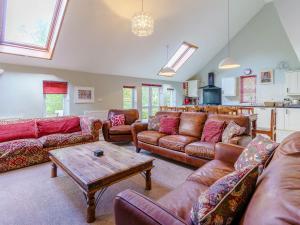 a living room with leather couches and a table at The Coach House - Uk35246 in Llanfyrnach