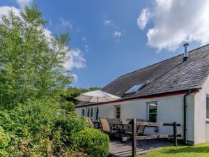 a house with a table and chairs on a patio at The Coach House - Uk35246 in Llanfyrnach
